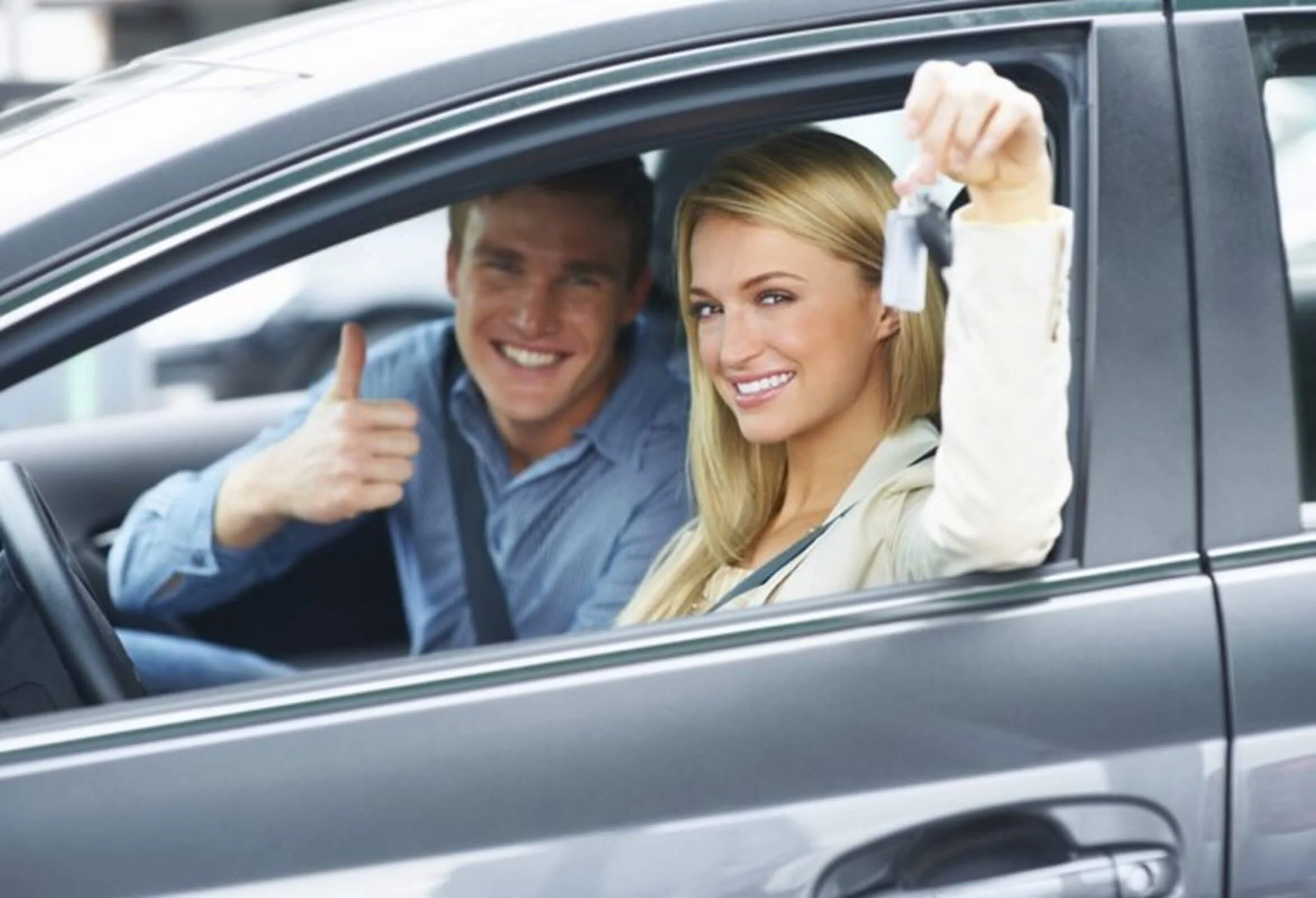 woman with car keys man thumbs up inside car