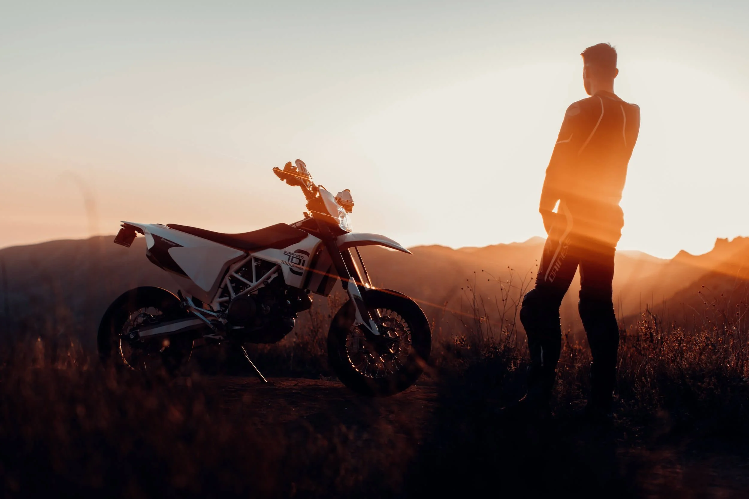 man standing beside dirt bike