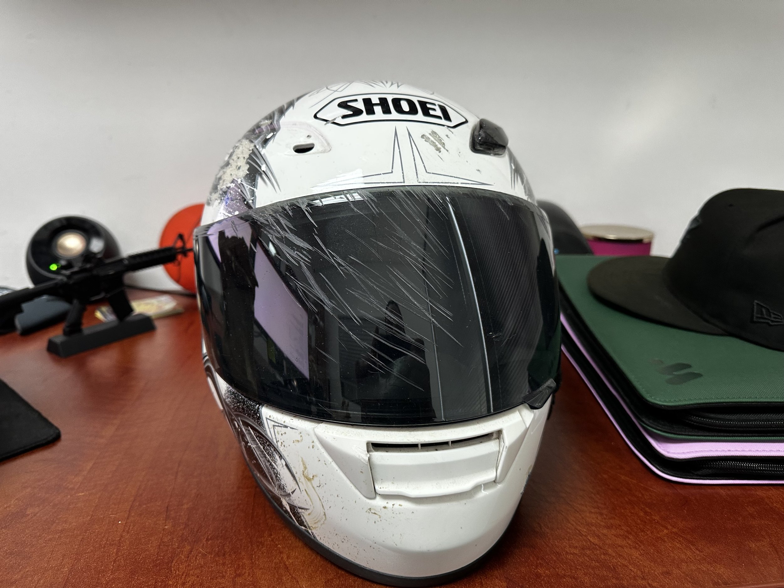 White Shoei motorcycle safety helmet with dark visor on desk