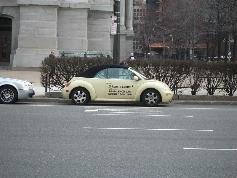 lemon colored car parked beside street