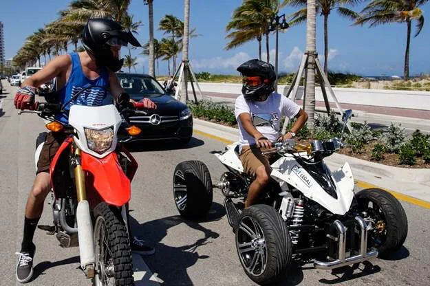 dirt bike rider and atv rider on street
