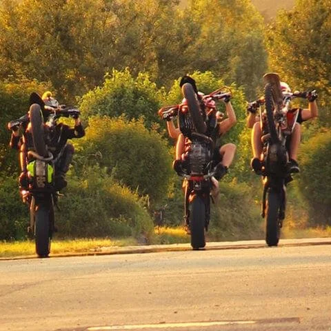 3 dirt bike riders doing wheelie