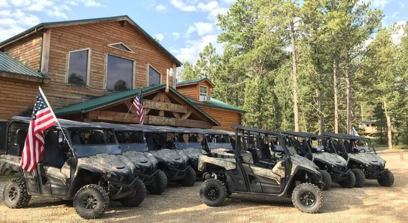 Yamaha UTVs US flags in front of wooden lodge