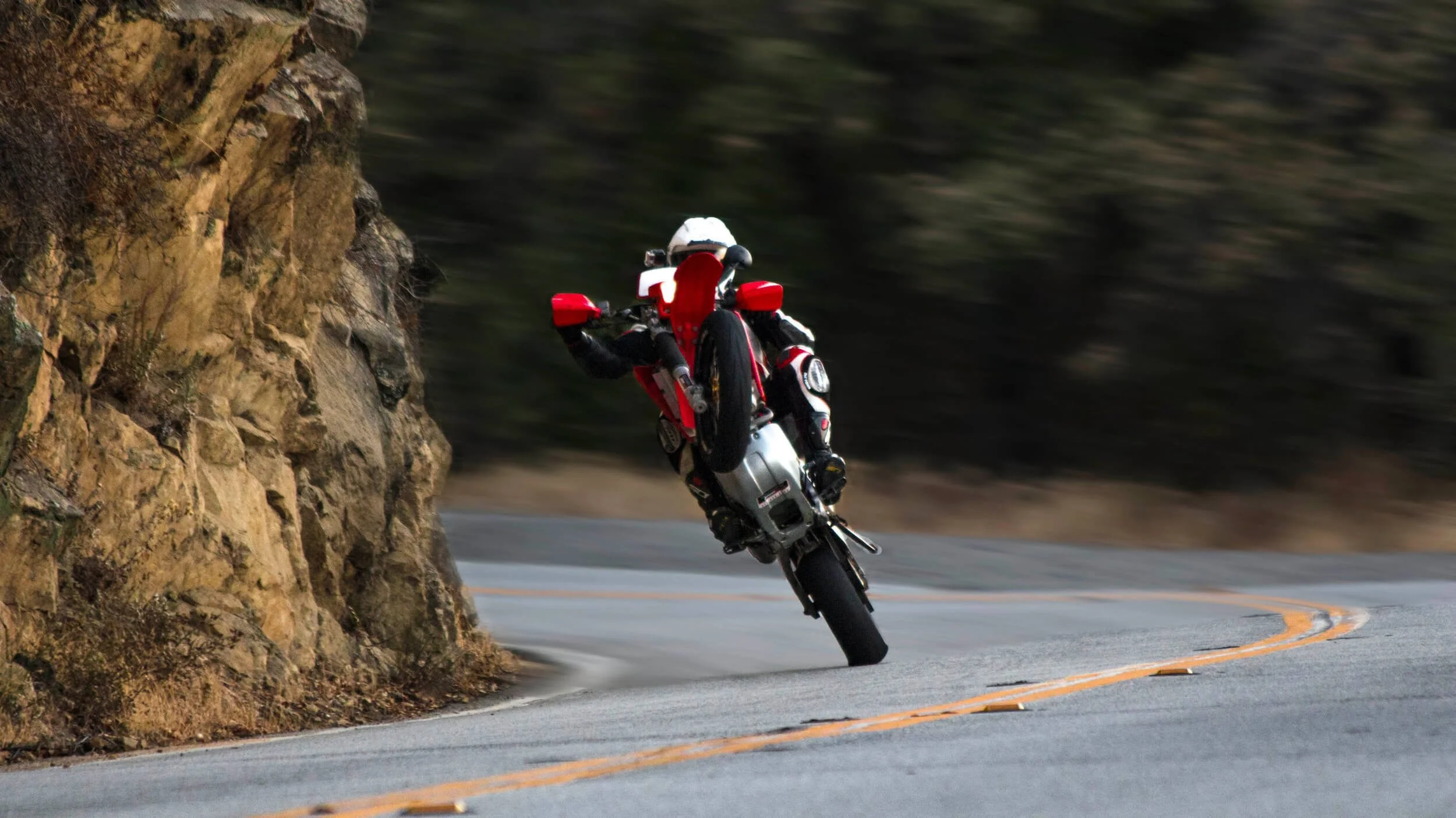 dirt bike rider doing wheelie on street