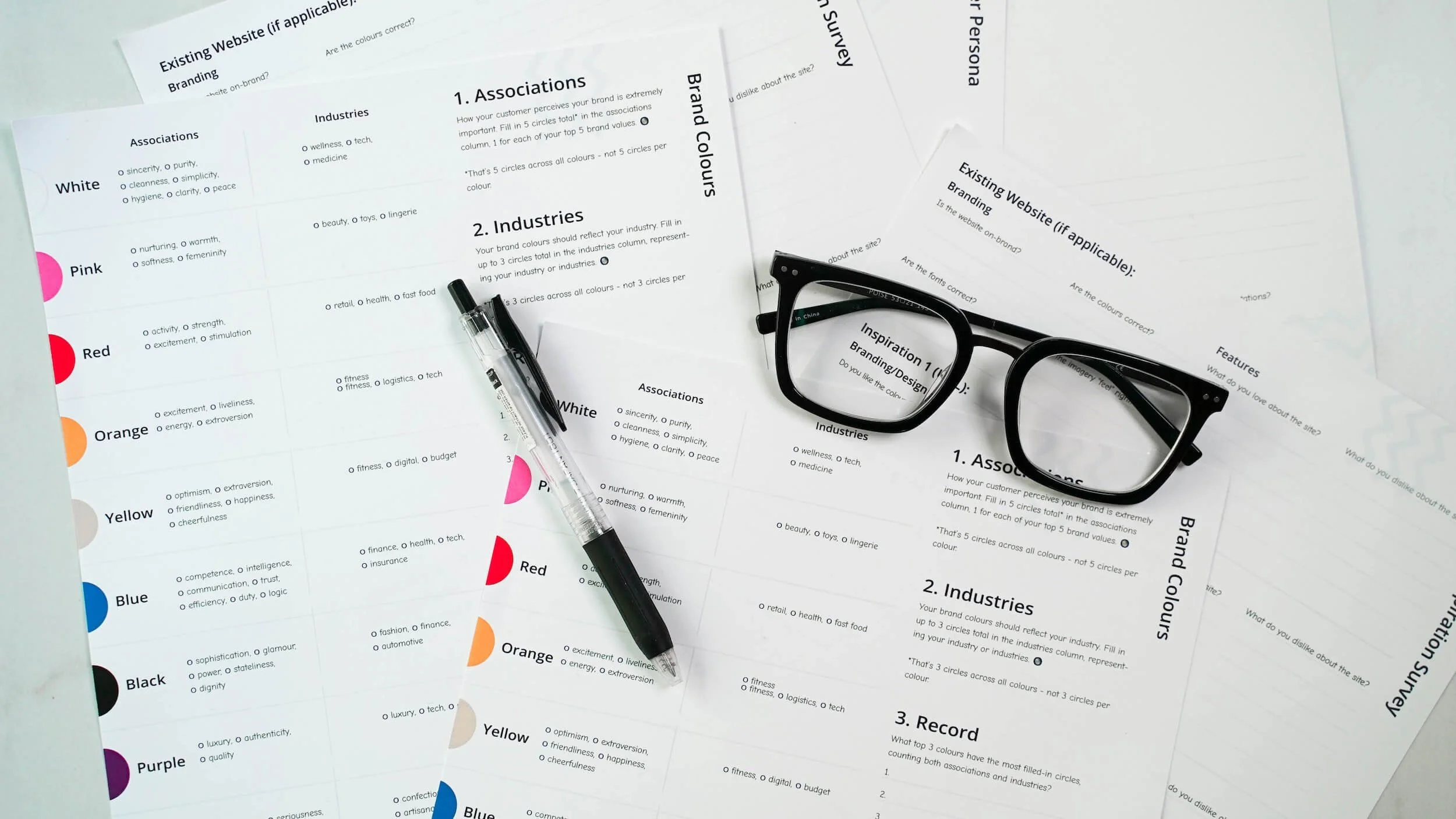glasses, pen, pile of paper