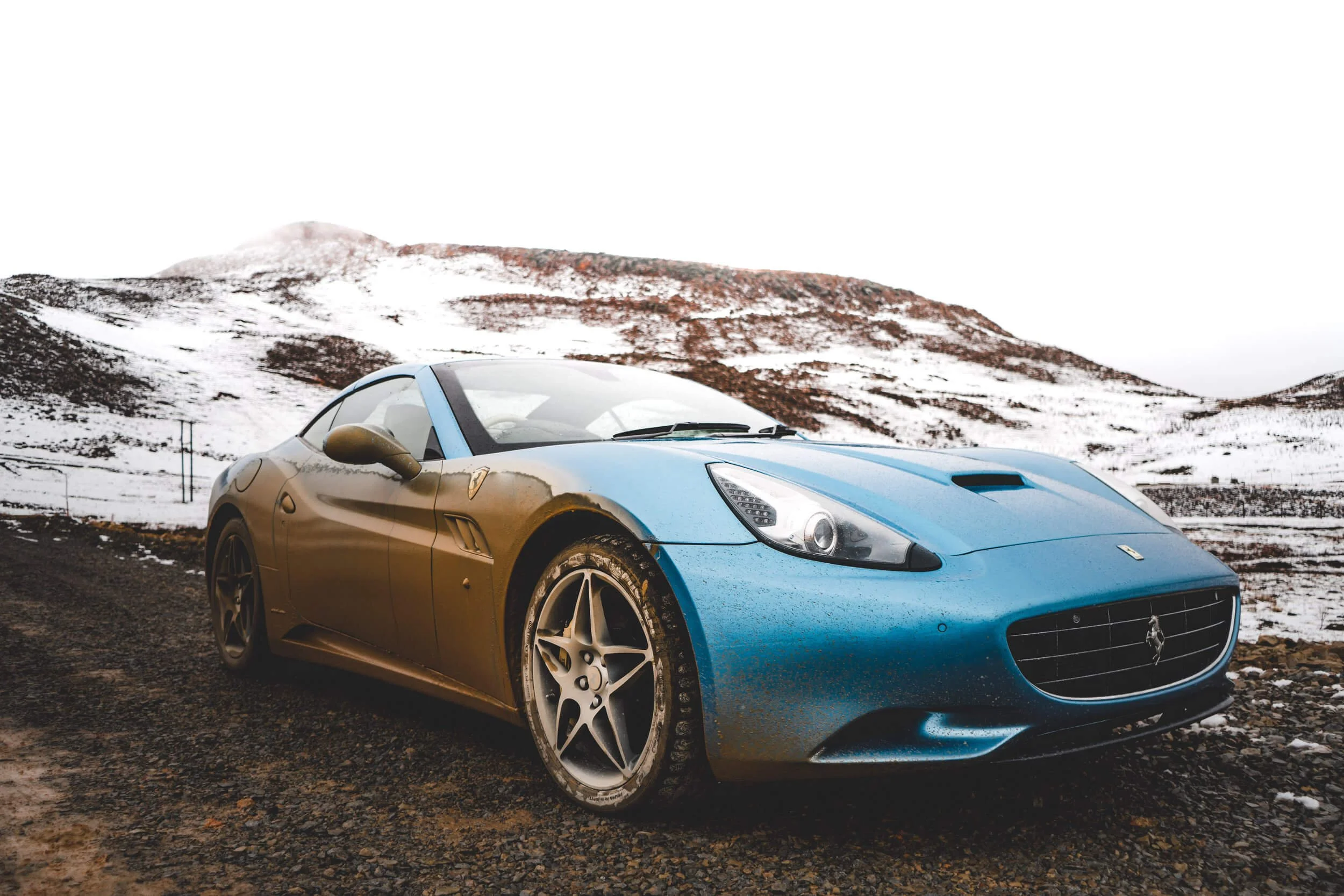 blue sports car on snow covered area