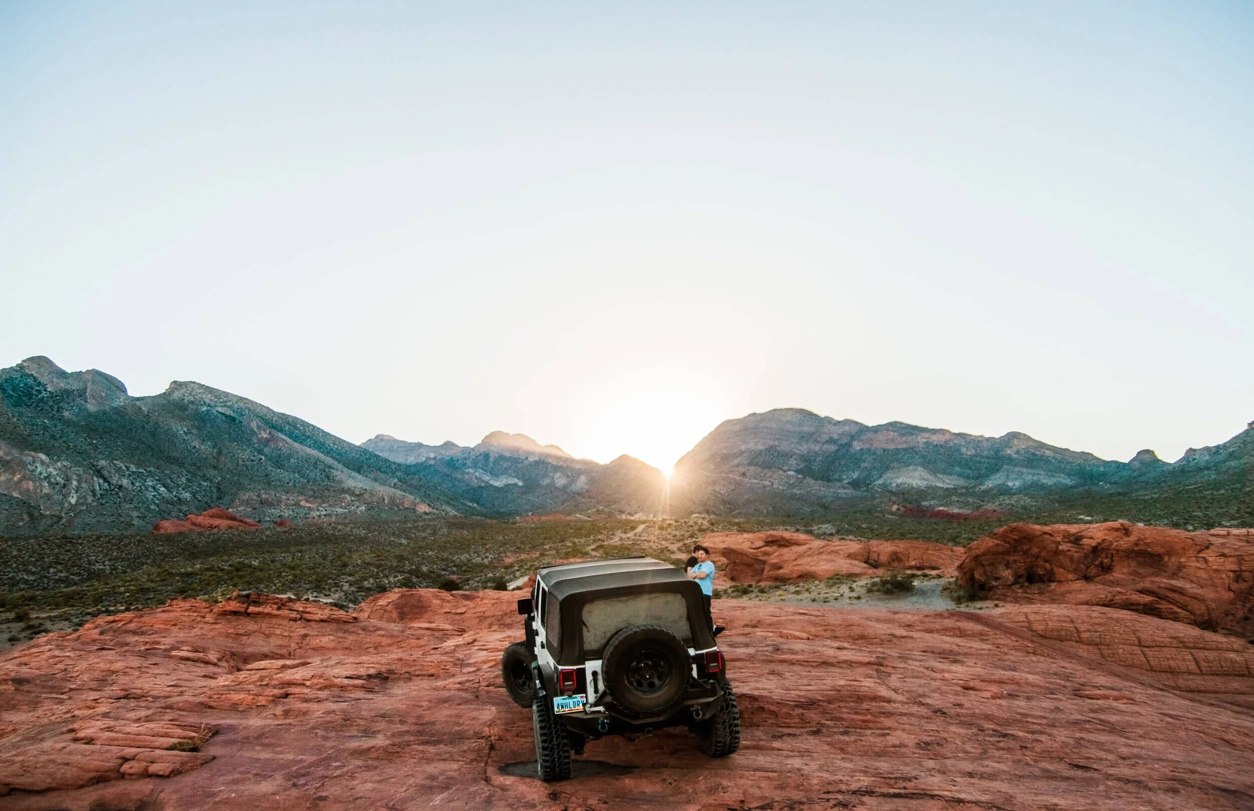 A person and 4X4 in a valley and mountain range
