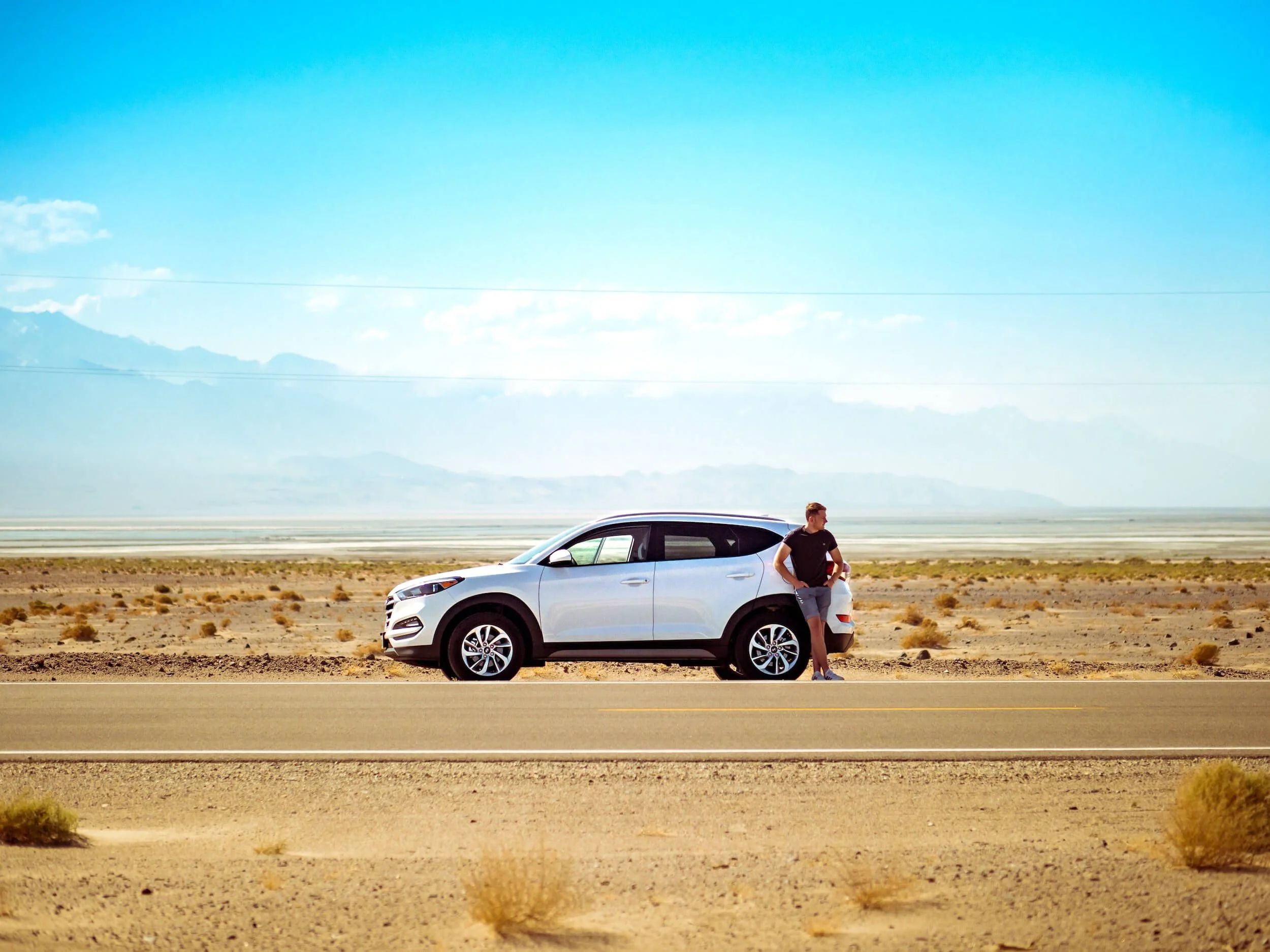 ban standing beside white suv beside road
