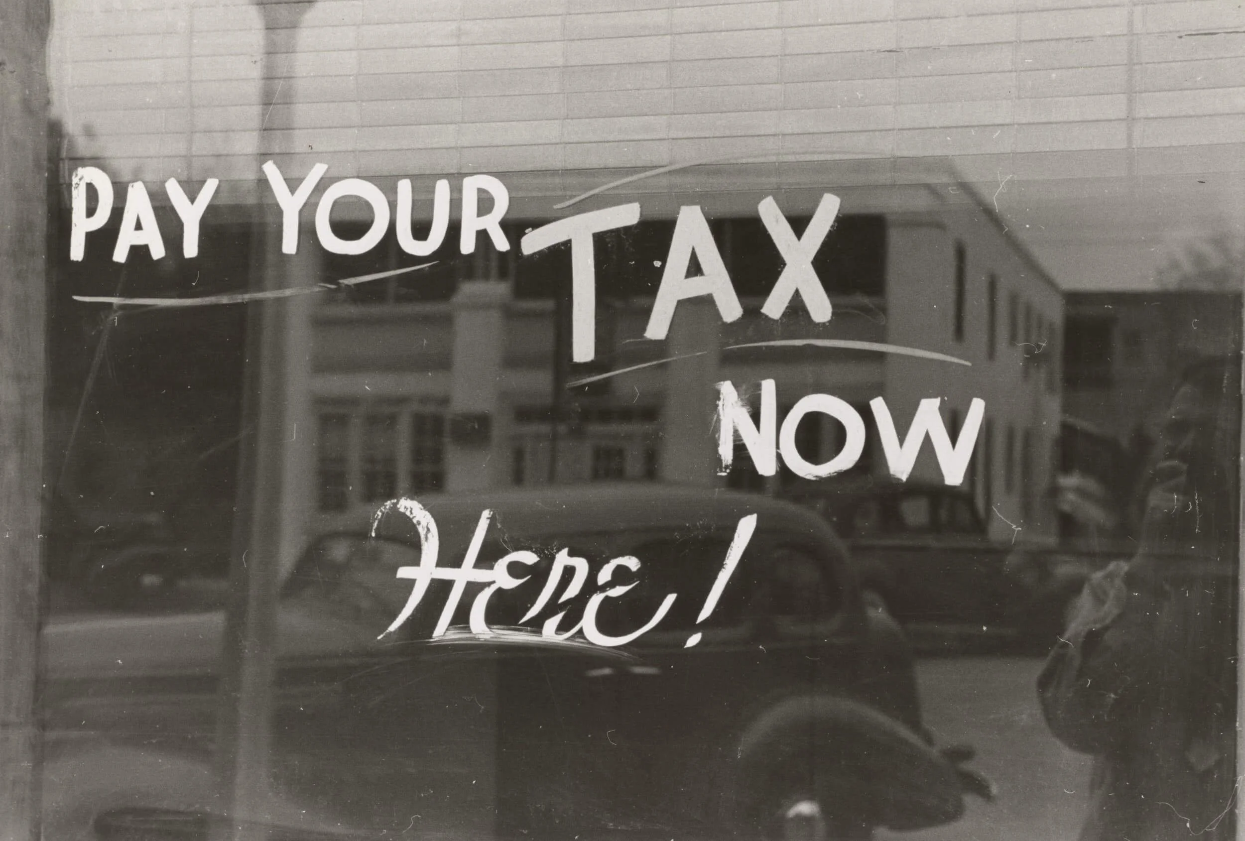 pay your tax now here! text written on glass wall