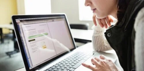 woman looking at laptop car title request