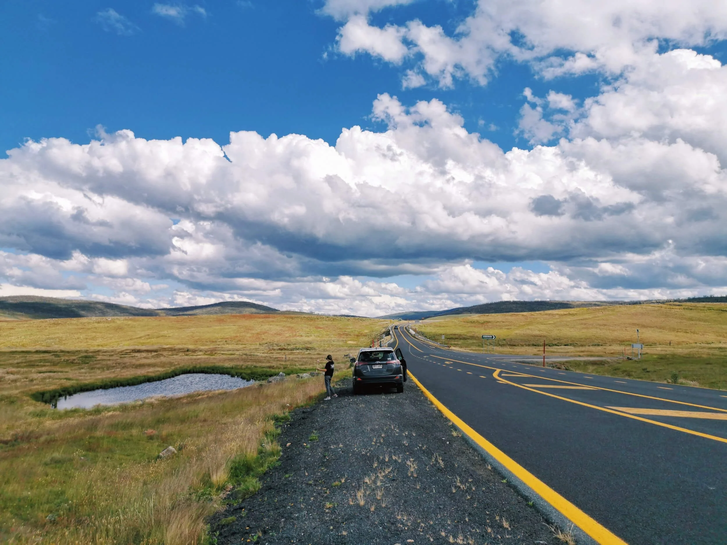 car parked beside road under blue sky