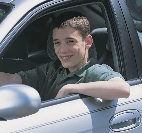 man smiling from inside car, drive without insurance arrested
